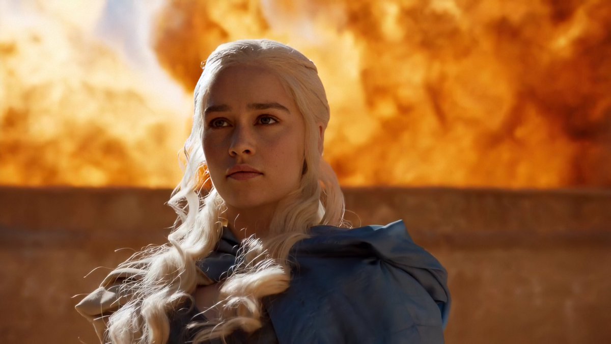 Emilia Clarke as Daenerys with fire burning in the background